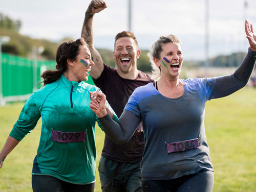 Three happy and healthy employees competing in a company promoted wellness run.