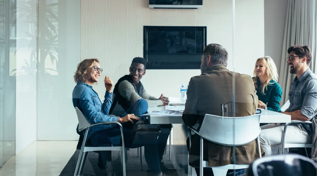 Executives in a boardroom discuss the benefits of offering biometric health screening to their employees.